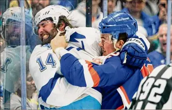  ?? Frank Franklin II / Associated Press ?? The Islanders’ Ross Johnston, right, punches Tampa Bay’s Pat Maroon early in New York’s 4-2 loss to the Lightning on Sunday afternoon at UBS Arena in Elmont.