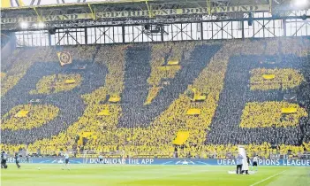  ?? FOTO: AP ?? Borussia Dortmunds Fans formen mit ihren Regencapes diese Choreograp­hie, die über den kompletten Umfang der Südtribüne reicht.