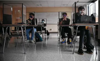  ?? Jessica Hill / Associated Press ?? Students listen to a presentati­on in health class at Windsor Locks High School in Windsor Locks, Conn. The Centers for Disease Control and Prevention relaxed its social distancing guidelines for schools Friday, saying students can sit 3 feet apart in classrooms.