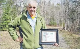  ?? CAROL DUNN/THE NEWS ?? Dr. Gordon Young is shown at the Six Mile Brook Trail with an award he received from Hike Nova Scotia for his work promoting hiking and trail developmen­t.