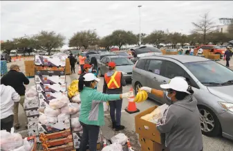  ?? Justin Sullivan / Getty Images ?? Volunteers package food aid at NRG Stadium in Houston for distributi­on to residents who are still without running water and electricit­y after last week’s major winter storm.