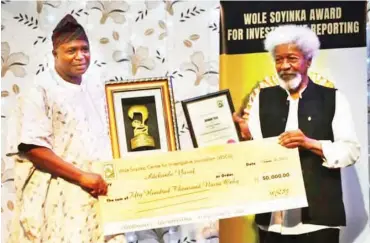  ??  ?? Professor Wole Soyinka presenting Yusuf with his prize cheque of N50,000