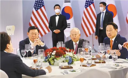  ?? Yonhap ?? Conglomera­te leaders attend a banquet hosted by the presidenti­al office on the occasion of the summit between President Yoon Suk-yeol and U.S. President Biden, at the National Museum of Korea in Yongsan District in central Seoul, Saturday. From left in the back are Lotte Group Chairman Shin Dong-bin, CJ Group Chairman Sohn Kyung-shik and SK Group Chairman Chey Tae-won.