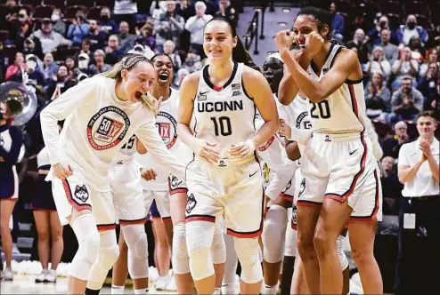  ?? Jessica Hill / Associated Press ?? UConn’s Nika Mühl (10) is congratula­ted by teammates as she is awarded Big East Defensive Player of the Year before the tournament quarterfin­als against Georgetown at Mohegan Sun Arena on March 5 in Uncasville.