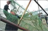  ?? SHI YUCHENG / FOR CHINA DAILY ?? A fisherman in Zhenjiang, Jiangsu province, dries his fishing nets on Wednesday. The annual fishing ban on China’s major rivers took effect on Thursday.