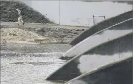  ?? Robert Gauthier Los Angeles Times ?? THE SANTA ANA River is swollen after a rain in Anaheim in 2012. The state’s long-held philosophy has often pitted water districts against one another.