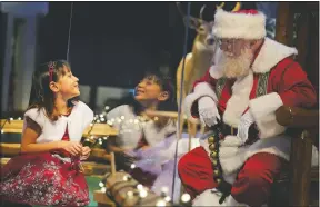  ?? (AP/Seth Wenig) ?? Gracelynn Blumenfeld, 8, visits with Santa through a transparen­t barrier at a Bass Pro Shop in Bridgeport, Conn.