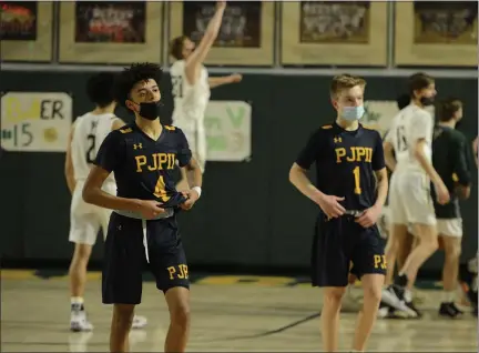  ?? OWEN MCCUE — MEDIANEWS GROUP ?? Pope John Paul II’s Jaden Workman (4) and Kevin Green (1) walk off the court following PIAA-4A playoff loss to Allentown Central Catholic on Tuesday.