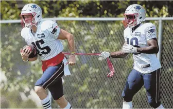  ?? STAFF PHOTO BY NANCY LANE ?? DRAG ROUTE: Chris Hogan goes through a drill while Matthew Slater slows him down with a resistance band during practice yesterday at Gillette Stadium.