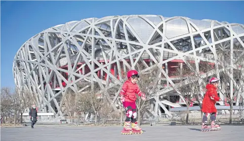  ?? AFP ?? Children skating outside the ‘Bird’s Nest’ stadium in Beijing where the opening and closing ceremonies of the 2022 Winter Olympics will take place.