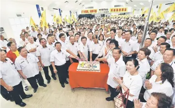  ??  ?? Dr Sim (third left, front row) with party leaders and members at the cake-cutting ceremony.