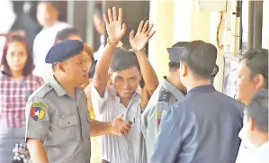  ??  ?? KYAW SOE (tengah) diiringi pihak polis ke dewan mahkamah di Yangon, semalam. — Gambar AFP