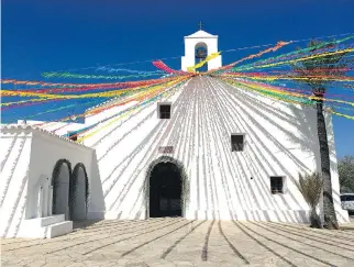  ??  ?? A church in the quiet village of Sant Vicent de sa Cala is decorated with a rainbow of colourful ribbons.