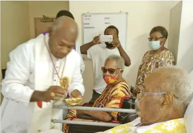  ??  ?? Cardinal Sir John Ribat at Sir Michael Somares’s bedside as Lady Veronica looks on at the Pacific Internatio­nal Hospital in Port Moresby, Papua New Guinea.