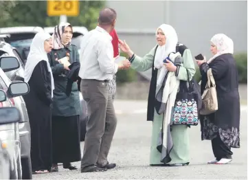  ??  ?? Members of a family react outside the mosque following a shooting.