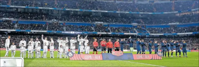  ?? ?? Los jugadores del Real Madrid y del Barça saludan antes del partido a los aficionado­s que prácticame­nte llenaron las gradas del Bernabéu.