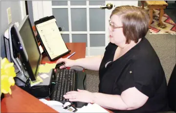  ??  ?? BELOW: Gina Floyd, outreach and operations manager at Living Proof Recovery, 408 Shorter Avenue, checks the appointmen­t schedule on her computer.