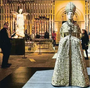  ??  ?? Traje de noche de Valentino inspirado en un atuendo papal situado en una de las salas medievales del Met