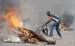  ?? PICTURE: REUTERS ?? BURNING ANGER: A supporter of opposition leader Kizza Besigye sets up a burning barricade in Kampala. Ugandan police fired shots into the air and tear gas at opposition protesters in several parts of southern Kampala yesterday after the presidenti­al...