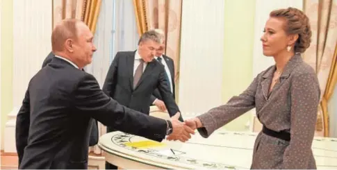  ?? POOL ?? Putin estrecha la mano de Ksenia Sobchak, en presencia de Grunidin
