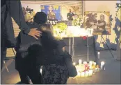  ?? CHRIS PIZZELLO — THE ASSOCIATED PRESS ?? Attendees embrace at a candleligh­t vigil for the late cinematogr­apher Halyna Hutchins, pictured in photograph­s in the background in Burbank.