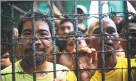  ?? ASSOCIATED PRESS ?? Inmates remain in their cell on Wednesday at the jail in the southern Philippine­s after a massive jailbreak.