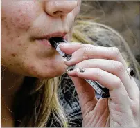  ?? STEVEN SENNE / ASSOCIATED PRESS 2018 ?? U.S. health authoritie­s have been more reluctant to back e-cigarettes, in part because there is little research on long-term effects of chemicals in e-cig vapor.