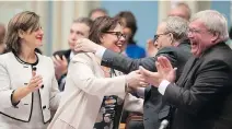  ?? JACQUES BOISSINOT/ THE CANADIAN PRESS ?? Lucie Charlebois is congratula­ted after the National Assembly adopted cannabis legislatio­n.
