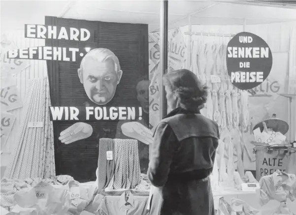  ?? Foto: akg-images ?? Zum Jahreswech­sel 1948/49 wurden Maßnahmen zur Preissenku­ng schließlic­h umgesetzt: Schaufenst­erauslage eines Textilgesc­häfts mit einem Porträt Ludwig Erhards.