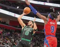  ?? Gregory Shamus / Getty Images ?? Jayson Tatum of the Celtics takes a second-half shot next to Jerami Grant of the Pistons. Tatum finished with 26 points.