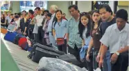  ??  ?? manilatime­s.net Overseas Filipino workers line up to get their belongings upon arrival at the Manila Internatio­nal Airport.