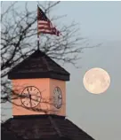  ?? MIKE DE SISTI / MILWAUKEE JOURNAL SENTINEL ?? The full moon sets over Riverpoint Village Shopping Center in Fox Point on April 30.