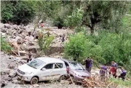  ?? — PTI ?? Mangled remains of vehicles after being washed away due to cloudburst­s in Kullu district on Thursday.