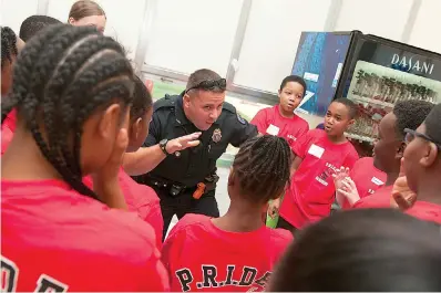  ?? Staff file photo by Jerry Habraken ?? ■ A Texarkana, Ark., police officer works with students on a team-building exercise during the opening of 2016 P.R.I.D.E. Academy at College Hill Middle School.