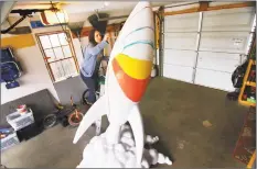  ?? Christian Abraham / Hearst Connecticu­t Media ?? Aubrey Booska, an art teacher at Eli Whitney School, paints a Fiberglas rocketship in the garage at her home on Wakelee Street in Stratford in March.