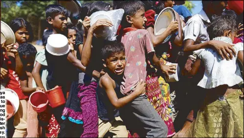  ??  ?? A Rohingya boy cries as he struggles to stay in a queue while waiting to receive food outside the distributi­on center in Bangladesh on Monday.