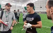  ?? Rob Maaddi/Associated Press ?? Welsh rugby star Louis Rees-Zammit, center, speaks to NFL scouts following pro day for NFL Internatio­nal Player Pathway prospects held at the University of South Florida on Wednesday in Tampa, Fla.