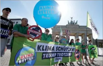  ?? FABRIZIOBE­NSCH / REUTERS ?? Environmen­tal activists of BUND protest in front of the Brandenbur­g Gate, beside the US embassy, against the US withdrawal from the Paris climate change deal in Berlin, Germany, on Thursday. The words read “Protect the climate. Brave Trump!”