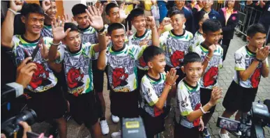  ??  ?? ‘Wild Boars’ soccer players and their coach arrive for their news conference in Chiang Rai yesterday.