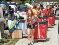  ?? PETE BANNAN – DIGITAL FIRST MEDIA ?? West Chester University student volunteers help freshmen and their families unload at Commonweal­th Hall during move-in day at the university.