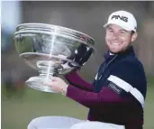  ?? — Reuters ?? England’s Tyrrell Hatton celebrates winning the Alfred Dunhill Links Championsh­ip with the trophy.