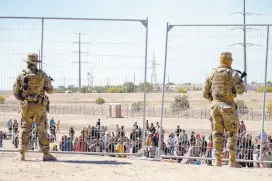  ?? ?? l Elementos de la Guardia Nacional de Texas vigilan a un grupo de migrantes en la frontera en El Paso.