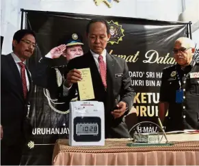  ??  ?? Back to work: Shukri clocking in at MACC headquarte­rs in Putrajaya. Looking on are his deputies (from left) Datuk Seri Mohd Azam Baki (operations) and Datuk Shamsun Baharin Mohd Jamil (prevention).