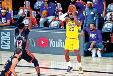  ??  ?? LeBron James van Los Angeles Lakers scoort een basket en geeft Bam Adebayo van Miami Heat het nakijken.