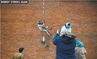  ?? BEN STANSALL AFP VIA GETTY IMAGES ?? The street artist Banksy confirmed on Instagram last week that he created the artwork that appeared on the side of the old Reading Prison in Reading, England, on Monday. The prison, famous for where writer Oscar Wilde served two years in the 1890s, closed in 2013. Campaigner­s want to turn it into an arts venue.