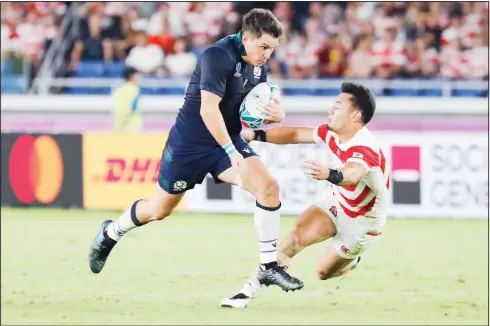  ??  ?? Scotland’s Sam Johnson runs past Japan’s Kenki Fukuoka during the Rugby World Cup Pool A game at Internatio­nal Stadium between Japan and Scotland in Yokohama,
Japan on Oct 13. (AP)