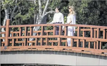  ?? MICHAEL ARES / THE PALM BEACH POST ?? Akie Abe, wife of Japanese Prime Minister Shinzo Abe, and first lady Melania Trump pause a moment to enjoy the scenery at the Morikami Museum and Japanese Gardens west of Delray Beach on Saturday.