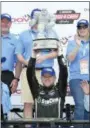  ?? NICK WASS — AP ?? Justin Allgaier hoists and poses with the trophy in Victory Lane after he won the NASCAR Xfinity series auto race, Saturday at Dover Internatio­nal Speedway in Dover, Del.