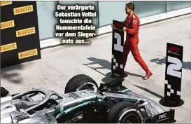  ??  ?? Der verärgerte Sebastian Vettel
tauschte die Nummerntaf­eln vor dem Siegerauto aus...