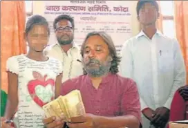  ?? HT PHOTO ?? Kota CWC chairman Harish Gurubaksha­ni with the two orphaned children. The children had written to the prime minister to help exchange the old ₹96,500 demonetise­d notes.
